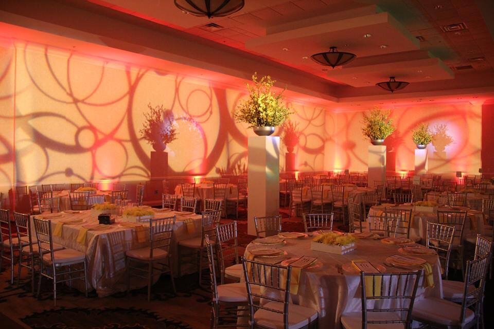 Coral and amber uplighting with a pattern wash across a banquet room