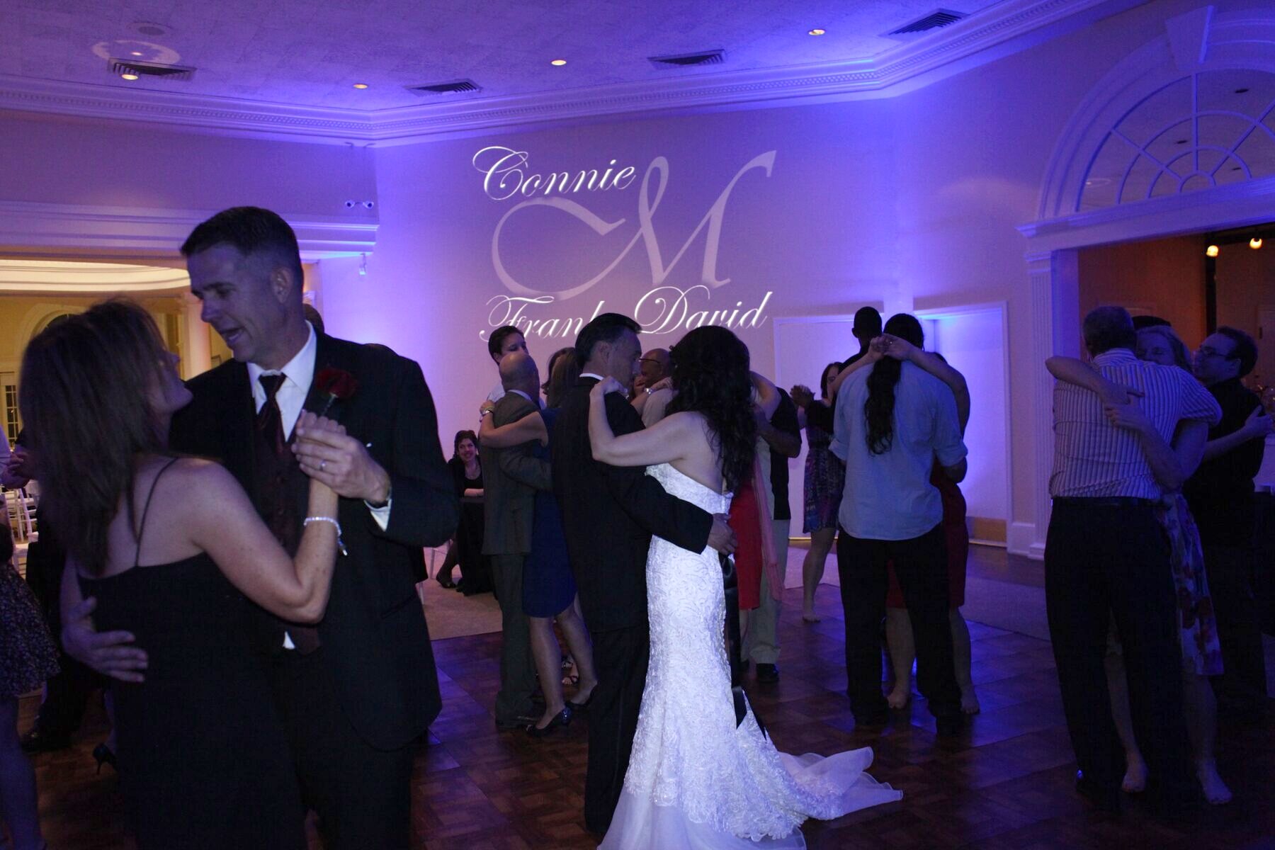 Violet uplighting and a custom monogram at a wedding reception